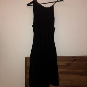 Black midi dress with green strap detailing.